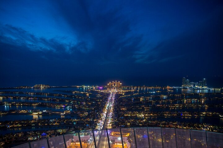 Marvel at the stunning skyline as the twinkling lights of Dubai come alive at night blending nature's beauty with architectural wonders for a truly unforgettable experience.
